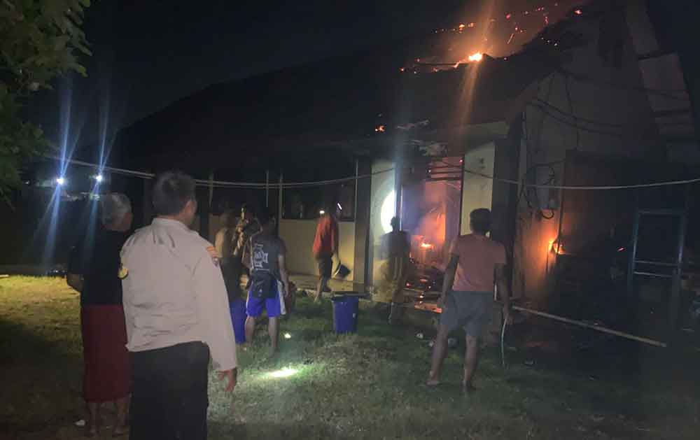 Warga berupaya memadamkan api dengan alat seadanya saat kebakaran terjadi.