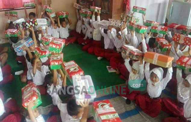 Para murid menunjukkan bingkisan yang diberikan oleh salah satu yayasan yang menyelenggarakan kegiatan wawasan kebangsaan.