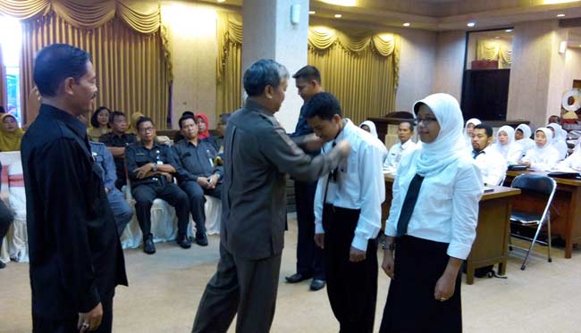 Plt Sekkab, Bambang Isdianto saat memasangkan dasi kepada para peserta diklat. foto: syuhud/ BANGSAONLINE