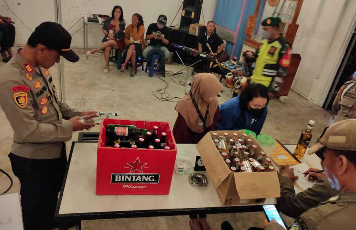 Petugas gabungan di Sidoarjo saat mengamankan puluhan botol miras yang dijual di warung.