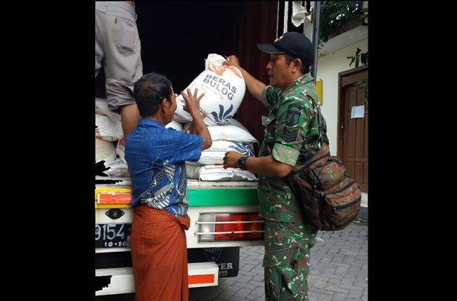Babinsa Koramil Semampir kawal distribusi beras untuk warga miskin.