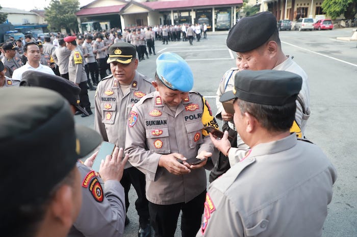 Kasi Propam Polres Kediri, AKP Sukiman saat sedang memeriksa HP salah satu personil. (Ist)