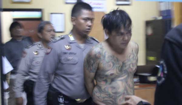 RESIDIVIS: Tersangka Jaya Santoso yang tubuhnya penuh tato ketika diamankan di Mapolsek Kota Sidoarjo. foto: catur andy erlambang/ BANGSAONLINE