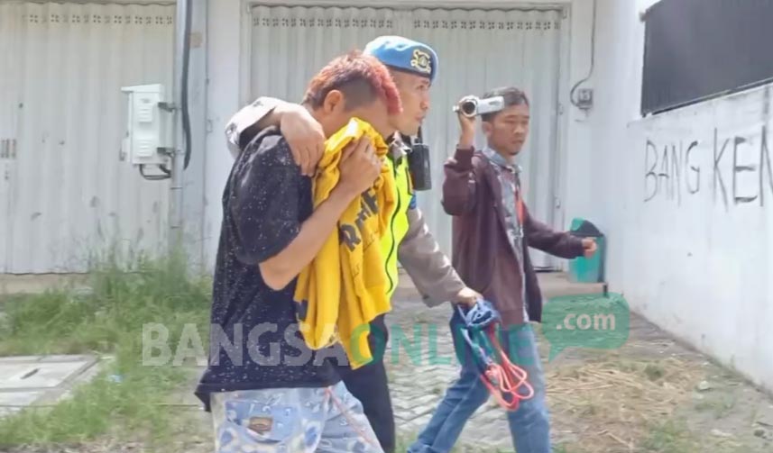 Satu oknum supporter yang kedapatan membawa senjata tajam (sajam) digelandang oleh polisi. foto: AKINA/ BANGSAONLINE