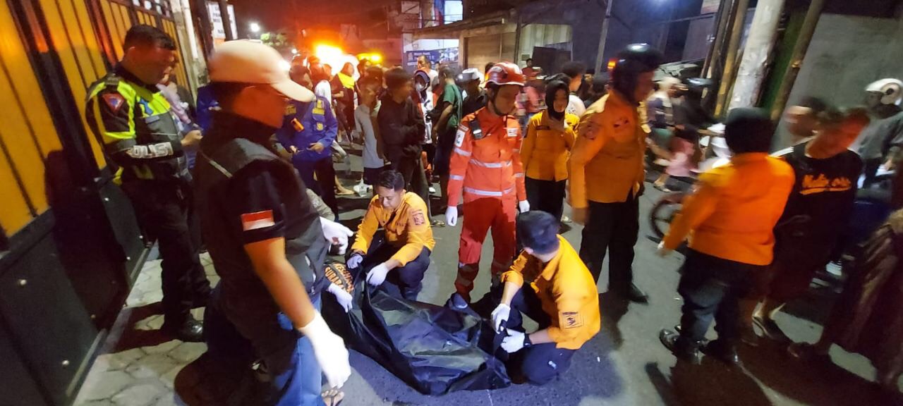 Petugas saat mengevakuasi jenazah korban