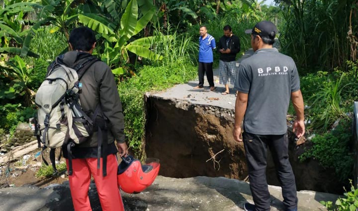 Badan jalan yang terputus akibat terjangan banjir. (foto: ist)