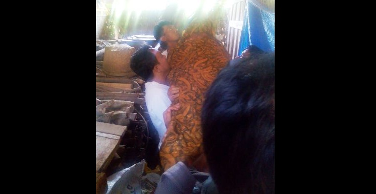 Petugas dari Polres Magetan di bantu warga menurunkan jenazah Marsini yang gantung diri di kandang kayu belakang rumah orang tuanya. foto: Nanang/BangsaOnline.com