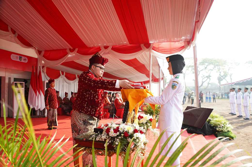 Bupati Kediri Hanindhito Himawan Pramana saat menyerahkan bendera merah putih kepada petugas pembawa bendera. (Ist)