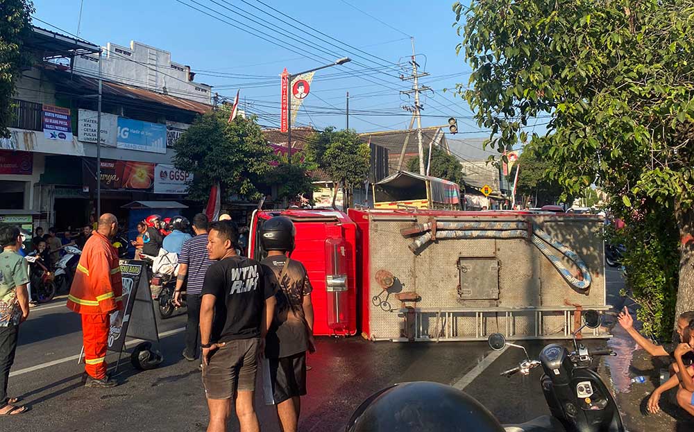 Truk damkar yang terguling di Jalan Tanjung Kota Blitar melintang hingga menutup setengah ruas jalan.