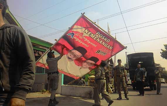 Panwaslu saat menurunkan baliho milik pasangan calon bupati yang melanggar. foto: dendi martoni/BANGSAONLINE