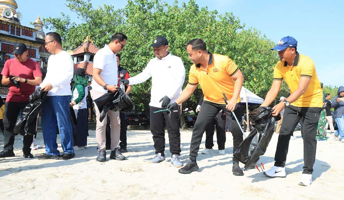 Kapolres Gresik AKBP Ramadhan Nasution bersama Bupati Fandi Akhmad Yani saat bersihkan sampah di Pantai Dalegan. foto: ist.