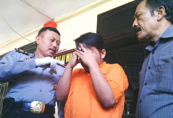 Tersangka saat diamankan di Mapolres Tanjung Perak. (foto: rusmiyanto/BANGSAONLINE)