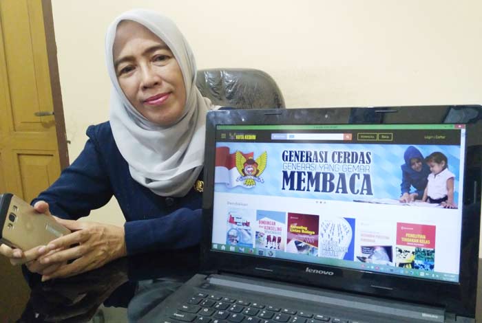 Kepala Dinas Perpustakaan dan Kearsipan Kota Kediri, Dewi Sartika, menunjukkan aplikasi e-Pusda.