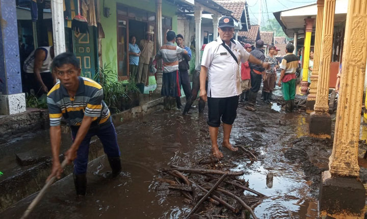 Warga dibantu aparat dan relawan membersihkan lumpur dan material yang terbawa saat banjir bandang. foto: ist.