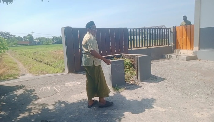 Pengurus masjid di Perumahan Arum sedang menunjukkan bak sampah yang terbuka tanpa ada penutupnya usai raib digondol kawanan maling.