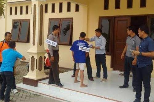 Pelaku saat memeragakan penusukan ketika dilakukan rekonstruksi di halaman Mapolres. foto: beritajatim