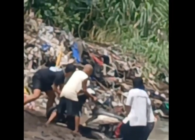 Tangkapan layar video saat warga menemukan motor yang terkubur di tepi sungai
