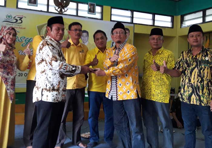 Ahmad Nurhamim saat menyerahkan potongan tumpeng ke Wanhat Marsudi. foto: SYUHUD/ BANGSAONLINE