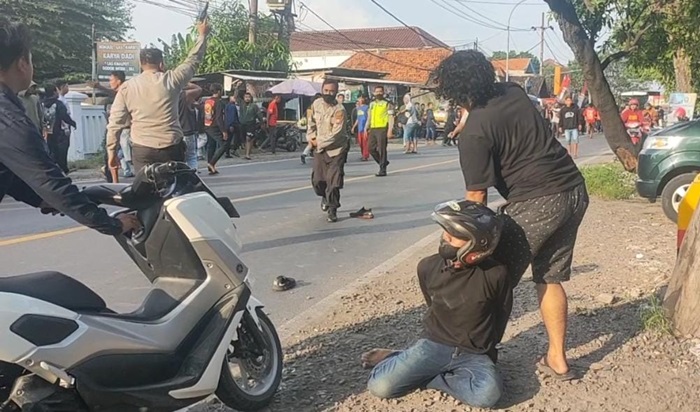 Petugas Polsek Cerme menembakkan senpi ke udara untuk membubarkan penyerang Pagar Nusa. foto: SYUHUD/BANGSAONLINE