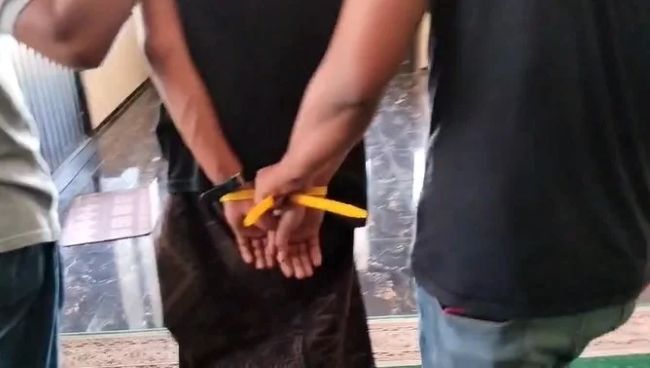Pelaku (tangan diikat) saat digelandang oleh anggota Reskrim Polres Bangkalan