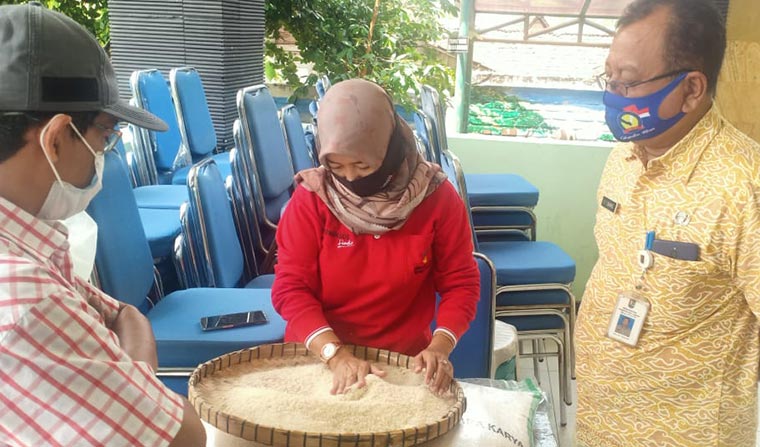 Pihak dinsos dan kecamatan saat mengecek kualitas beras yang akan disalurkan ke KPM.