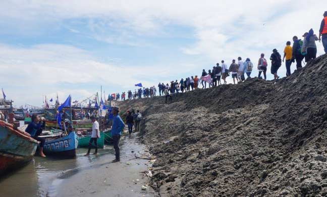 TOLAK REKLAMASI: Warga berbaris di gunungan pasir Pulau G saat penyegelan pulau, belum lama ini. foto: kompas.com