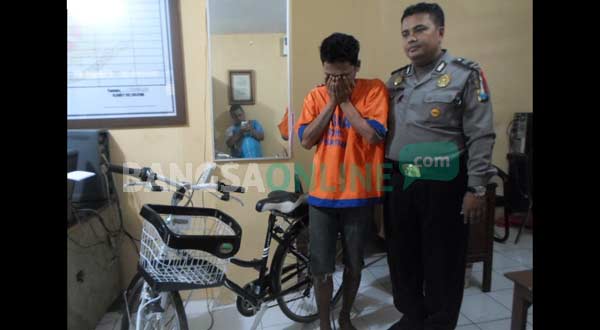 Tersangka saat diamankan di Mapolsek Taman bersama barang bukti. foto: catur/ BANGSAONLINE