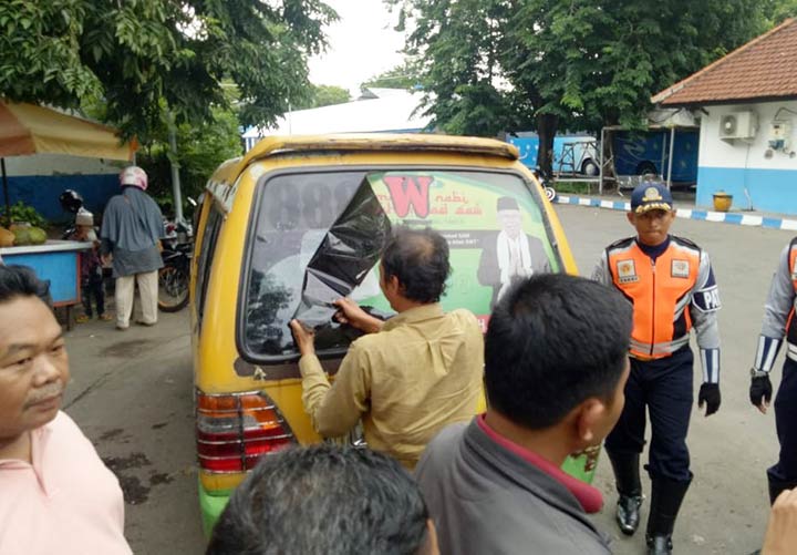 MELANGGAR: Bawaslu Sidoarjo mencopot stiker APK yang ditempel di Angkot, di Terminal Larangan Candi, Jumat (28/12). foto: ist.