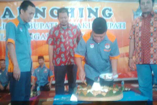 Bupati Fadeli memotong tumpeng dalam acara Launching pemilihan Bupati dan Wakilnya. (foto: haris/BANGSAONLINE)