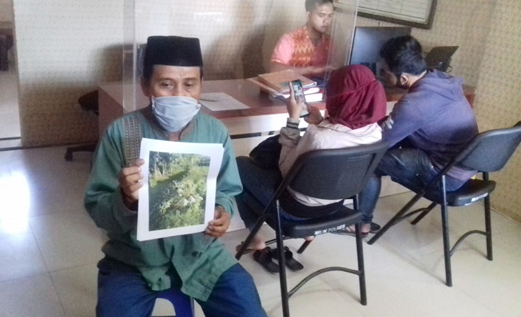 Darsun menunjukkan bukti laporan ke polisi.