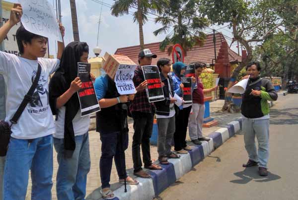 SOLIDARITAS: Anggota AJI Bojonegoro tampak membentangkan poster di depan Mapolres Bojonegoro. Foto: eky nurhadi/BANGSAONLINE