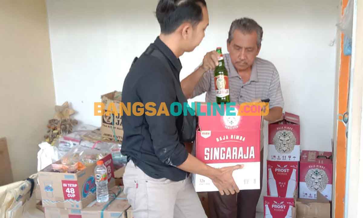 Petugas dari Polres Gresik saat mengamankan miras hasil dirazia. Foto: SYUHUD/BANGSAONLINE