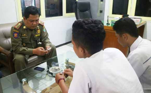 Dandung Djulharjanto, Kabid Trantib Satpol PP Kota Malang, saat memeriksa Hp milik salah satu siswa yang kedapatan menyimpan foto tidur berdua dengan pacarnya.