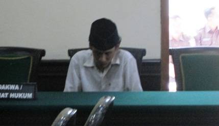 MENUNDUK – Terdakwa saat sidang di PN Mojokerto. foto: Agus/BangsaOnline.com