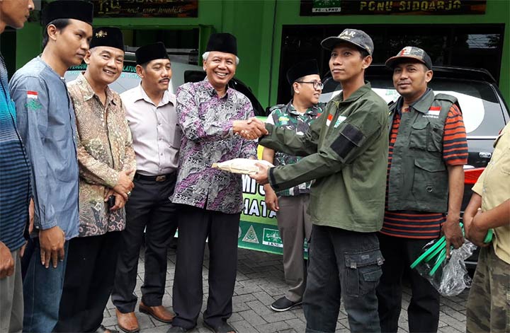 SIMBOLIS: Wakil Ketua PCNU Sidoarjo KH Moh Kirom saat memberangkatkan bantuan Tsunami Selat Sunda, Kamis (17/1). foto: MUSTAIN/ BANGSAONLINE