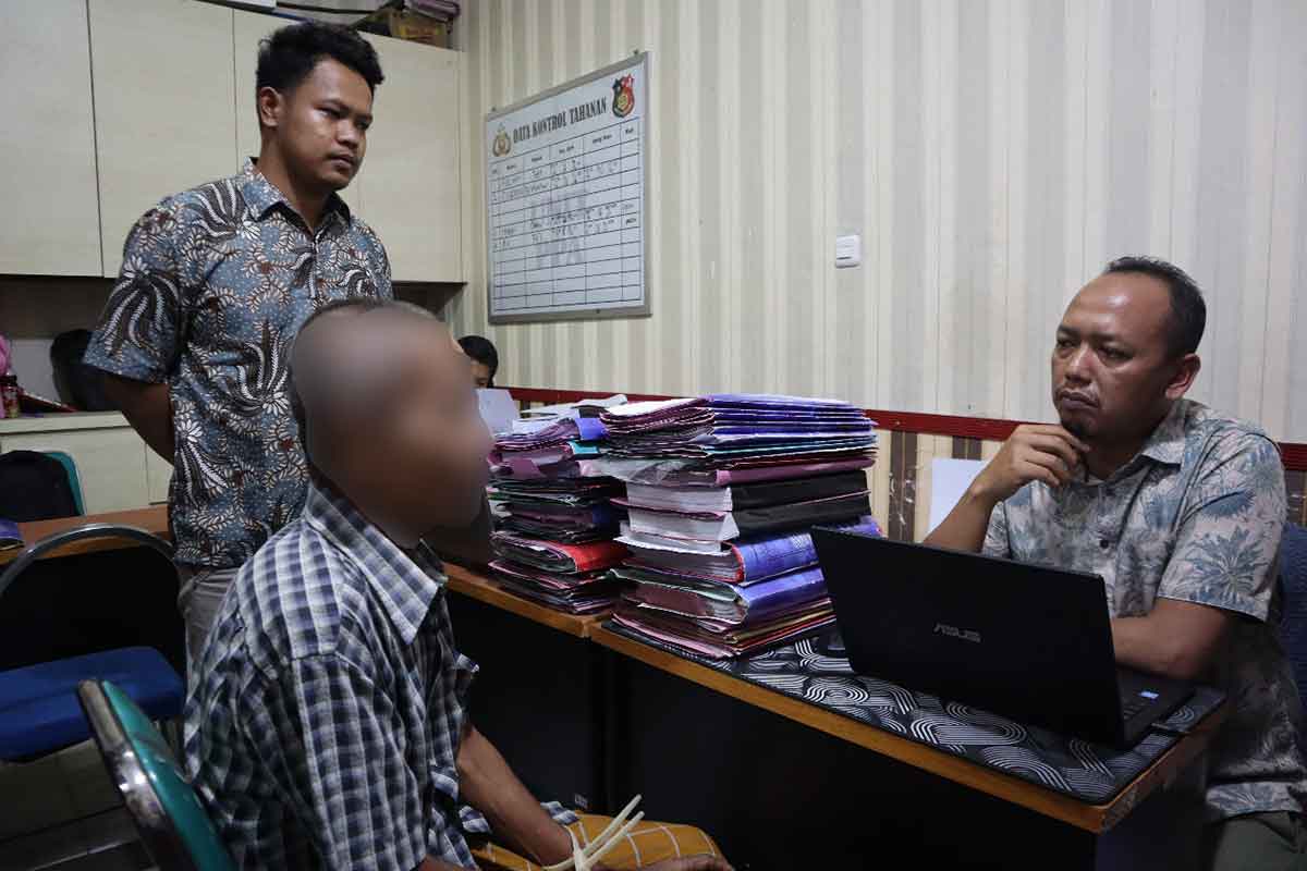 Petugas dari Satreskrim Polres Bangkalan saat menginterogasi pelaku yang tega memperkosa anak angkatnya.