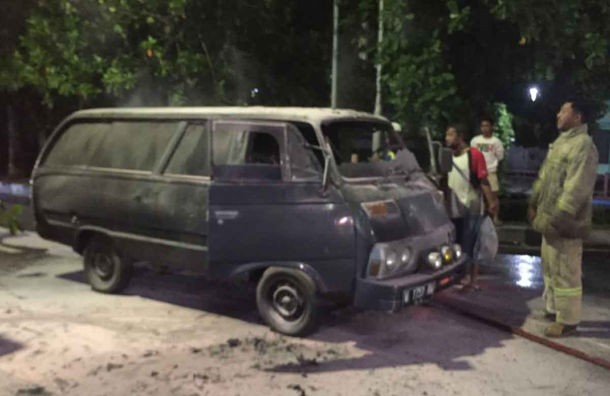 Petugas saat mengevakuasi mobil yang hangus terbakar.