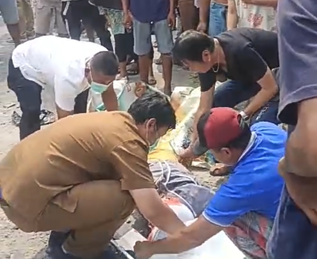 Petugas saat mengevakuasi korban di jalan raya Morowudi