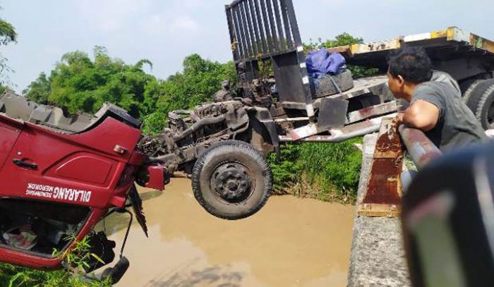 Separuh badan truk menggantung di atas Sungai Gunting.
