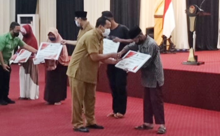 Kadinsos Kota Pasuruan Hery Dwi Sudjatmiko saat menyerahkan BLT secara simbolis kepada 5.319 KPM.