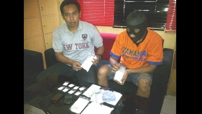 BUKTI – Anggota Satnarkoba Polres Sidoarjo menunjukkan barang bukti pil koplo dan tersangka Sastro Wibowo (memakai baju tahanan), di ruang  penyidik Satnarkoba Polres Sidoarjo, Selasa (10/3). foto: nanang ichwan/BangsaOnline.com