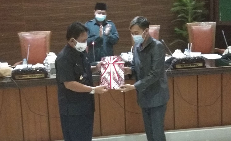 Plt. Bupati Nganjuk Marhaen Jumadi saat menyerahkan jawaban terkait hak interpelasi kepada Wakil Ketua II DPRD Nganjuk Raditya Harya Yuangga. (foto: BAMBANG DJ/BANGSAONLINE)