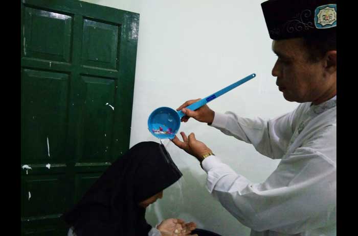 Salah satu siswa ketika disiram dengan air kembang. foto: SYUHUD/ BANGSAONLINE