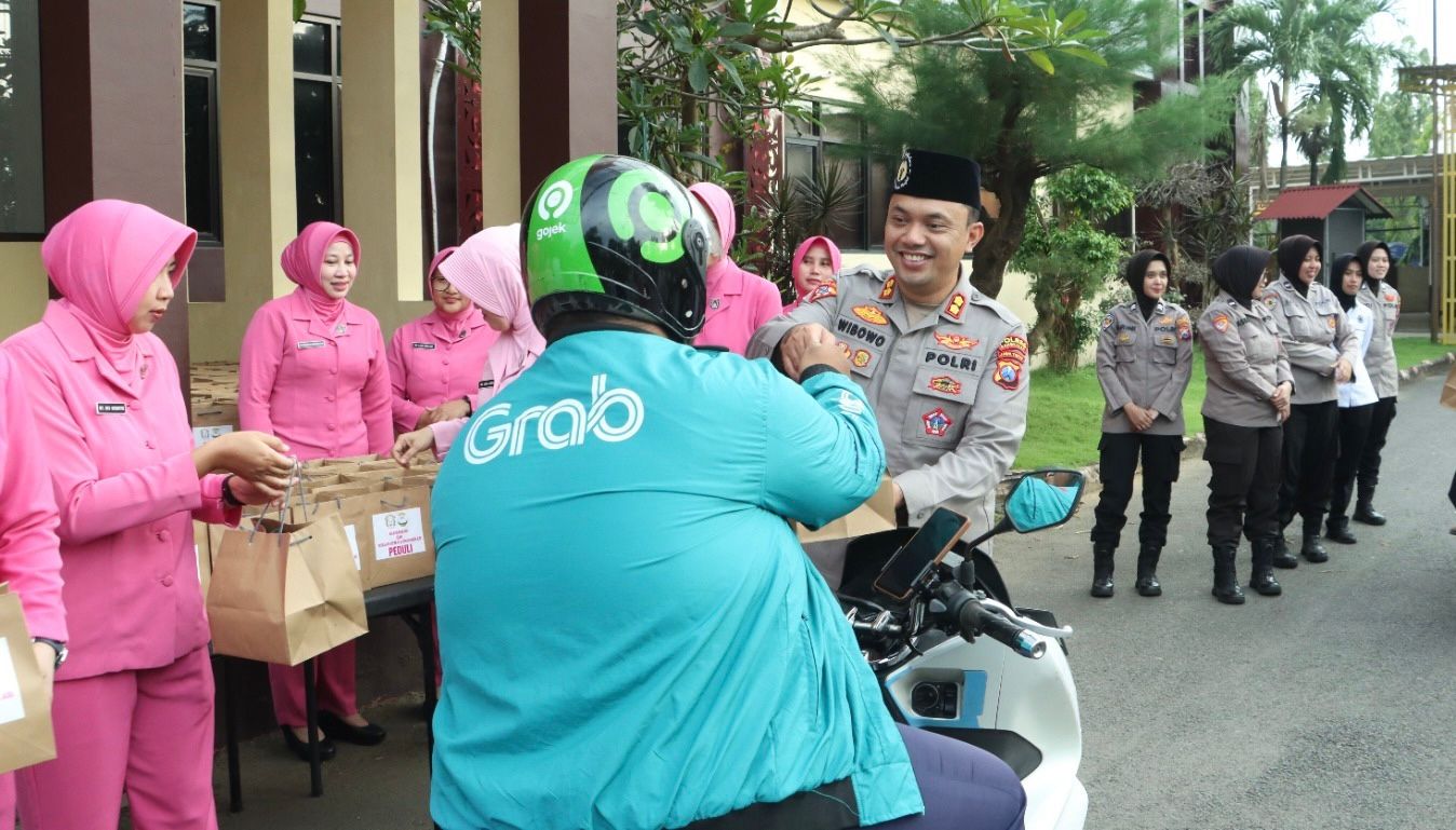 Kapolres Bangkalan, AKBP Wibowo saat memberikan paket takjil kepada driver ojol yang melintas di depan Mapolres