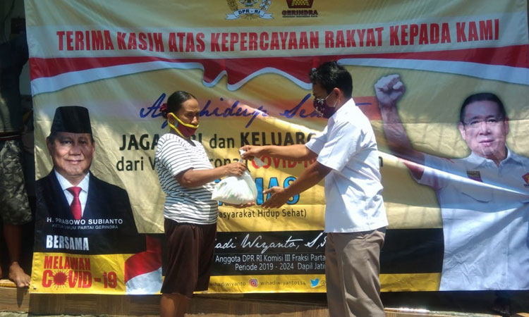 Relawan Wihadi membagikan paket sembako kepada ibu-ibu.