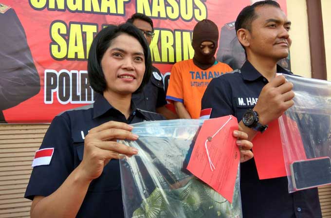 Kompol Muhammad Harris (kanan) menunjukkan barang bukti berupa pakaian korban.