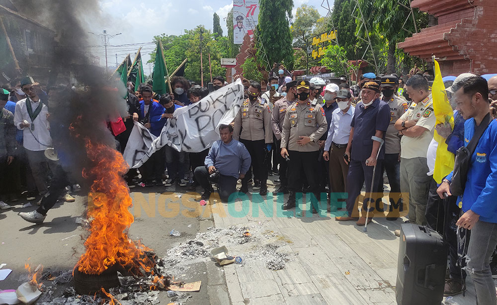 Aliansi Mahasiswa Mojokerto Raya berdemo di depan kantor Pemkot Mojokerto sambil bakar ban. Foto: YUDI EP/ BANGSAONLINE