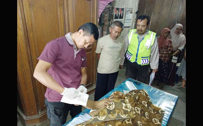 Korban yang melakukan gantung diri di pohon mangga Senin pagi tadi sedang dilakukan pemeriksaan oleh tim medis dan anggota polisi.