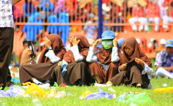 SUMUK: Para peserta yang tampak menutupi menutupi wajah mereka dari sengatan terik matahari dengan alat seadanya. foto: eky nurhadi/ BANGSAONLINE
