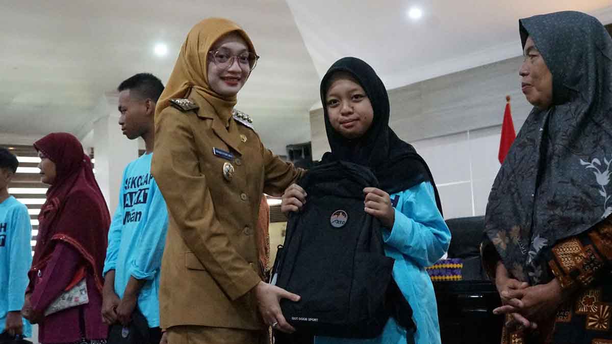 Wali Kota Kediri saat menyerahkan bantuan tas sekolah kepada salah satu calon siswa SRMP. Foto: Ist